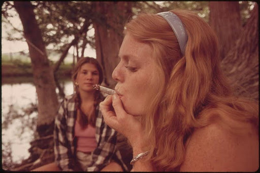 A young girl is smoking a cigarette